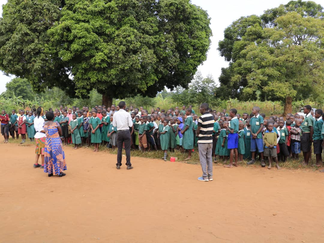 A facilitator addressing a full school assembly